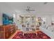 Bright living room with white sofas, wood floors, large TV, and a vibrant oriental rug at 4945 Nw 35Th Lane Rd, Ocala, FL 34482