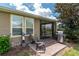 A cozy brick patio is furnished with chairs and a grill for outdoor entertaining, leading to a screened porch at 4945 Nw 35Th Lane Rd, Ocala, FL 34482