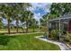 Inviting backyard featuring a covered patio, manicured lawn, and mature palm trees at 5195 Nw 21St Loop, Ocala, FL 34482