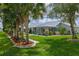 Large backyard with a screened-in lanai, vibrant landscaping, and a neatly trimmed lawn at 5195 Nw 21St Loop, Ocala, FL 34482