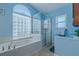 Bathroom with a large soaking tub and separate glass enclosed shower, enhanced by natural light at 5195 Nw 21St Loop, Ocala, FL 34482