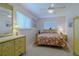 Cozy bedroom features a floral comforter, ceiling fan, matching bedside tables and a bright window at 5195 Nw 21St Loop, Ocala, FL 34482