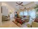 Bright living room featuring tile flooring, a ceiling fan, and large windows providing natural light at 5195 Nw 21St Loop, Ocala, FL 34482