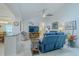 Bright living room with tile flooring, modern ceiling fan, and comfortable blue reclining sofa at 5195 Nw 21St Loop, Ocala, FL 34482