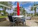 A covered brick patio with an outdoor dining table and chairs under a red umbrella at 5195 Nw 21St Loop, Ocala, FL 34482