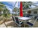 Covered brick patio with a white dining table and seating for four under a red umbrella at 5195 Nw 21St Loop, Ocala, FL 34482