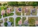 A top-down perspective revealing homes and yards with an emphasis on solar panels and pool, surrounded by lush green spaces at 5770 Sw 89Th Pl, Ocala, FL 34476