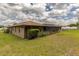 A house with a screened-in pool, grass, and a blue sky with clouds at 5770 Sw 89Th Pl, Ocala, FL 34476