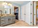 Bright bathroom featuring granite countertop vanity and a walk-in closet, tile floors, and adjacent closet at 5770 Sw 89Th Pl, Ocala, FL 34476
