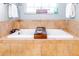 Well-lit bathroom with a soaking tub and a plant-filled window at 5770 Sw 89Th Pl, Ocala, FL 34476