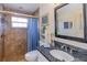 Well-lit bathroom featuring a tiled walk-in shower and granite countertop at 5770 Sw 89Th Pl, Ocala, FL 34476