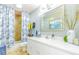 This bathroom offers a white vanity, a tiled shower, and ample lighting at 5770 Sw 89Th Pl, Ocala, FL 34476