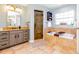 Serene primary bathroom featuring a soaking tub, a walk-in shower, and a stylish vanity with granite countertops at 5770 Sw 89Th Pl, Ocala, FL 34476