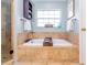 Bright bathroom featuring a soaking tub and tiled walls at 5770 Sw 89Th Pl, Ocala, FL 34476