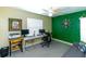 Office with a modern desk, gray carpet, a ceiling fan, and a decorative green wall at 5770 Sw 89Th Pl, Ocala, FL 34476
