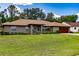 A well-maintained home featuring a lush front lawn, mature landscaping, and an inviting exterior at 5770 Sw 89Th Pl, Ocala, FL 34476