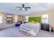 Spacious main bedroom with trey ceiling, a chaise lounge, and neutral tones at 5770 Sw 89Th Pl, Ocala, FL 34476