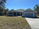 Charming single-story home with a manicured lawn, a two-car garage, and a welcoming covered porch at 6104 Sw 147Th Street Rd, Ocala, FL 34473