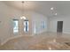 Bright living room featuring tile floors, large windows, and a modern chandelier at 6104 Sw 147Th Street Rd, Ocala, FL 34473