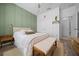 Charming bedroom featuring green accent wall, fan and white linens at 6437 Sw 45Th Ave, Ocala, FL 34474