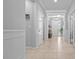 Well-lit hallway showcasing neutral paint, white trim, tile floors and leading to the front entry of the home at 6437 Sw 45Th Ave, Ocala, FL 34474