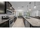 Stylish kitchen featuring dark cabinets, granite countertops, stainless steel appliances, and an open flow to the dining area at 6437 Sw 45Th Ave, Ocala, FL 34474