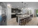 Modern kitchen featuring dark cabinetry, a granite island with seating, stainless steel appliances, and tile backsplash at 6437 Sw 45Th Ave, Ocala, FL 34474