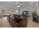 Comfortable living room features a brown leather sectional, wood accent wall, and a ceiling fan at 6437 Sw 45Th Ave, Ocala, FL 34474