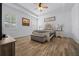 A bedroom with wood-look floors, plantation shutters, ceiling fan, and a lovely upholstered bed frame at 6437 Sw 45Th Ave, Ocala, FL 34474