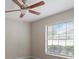 Bedroom features a ceiling fan, neutral walls, and view of the backyard at 802 Se 50Th Ter, Ocala, FL 34471