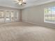 Spacious living room featuring a ceiling fan, neutral carpet, and glass doors to an outdoor patio at 802 Se 50Th Ter, Ocala, FL 34471