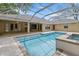 Sparkling pool features spa and steps, all in screened-in enclosure at 802 Se 50Th Ter, Ocala, FL 34471