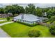 Lush backyard featuring a screened-in pool, manicured lawn, privacy fence, and mature landscaping at 828 Ne 51St Ave, Ocala, FL 34470