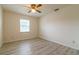 View of bedroom with gray wood-look floors, ceiling fan, white walls and window at 828 Ne 51St Ave, Ocala, FL 34470