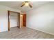 View of bedroom with gray wood-look floors, closet, white walls and ceiling fan at 828 Ne 51St Ave, Ocala, FL 34470