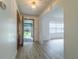 View of entryway with wood door, gray wood-look floors and white walls that opens to the outdoors at 828 Ne 51St Ave, Ocala, FL 34470