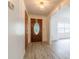 View of entryway with wood door, gray wood-look floors and white walls that opens to the living space at 828 Ne 51St Ave, Ocala, FL 34470