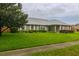 Well-maintained front yard with a brick home, manicured bushes, and a large shade tree at 828 Ne 51St Ave, Ocala, FL 34470