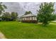 Brick home with a well-kept lawn, mature trees, and trimmed shrubs in a quiet neighborhood at 828 Ne 51St Ave, Ocala, FL 34470