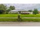 Charming single-story brick home with a lush green lawn, mature landscaping, and white shutters at 828 Ne 51St Ave, Ocala, FL 34470