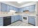 Charming kitchen with blue cabinets, white countertops, and stainless-steel appliances at 828 Ne 51St Ave, Ocala, FL 34470