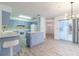 Kitchen area with light blue cabinets, an island, and white appliances at 828 Ne 51St Ave, Ocala, FL 34470