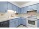 Well-maintained kitchen with light blue cabinets, white countertops, and stainless-steel appliances at 828 Ne 51St Ave, Ocala, FL 34470