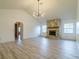 Open living room features vaulted ceiling, wood-look floors, stone fireplace and modern light fixture at 828 Ne 51St Ave, Ocala, FL 34470