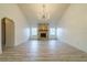 Spacious living room features stone fireplace, wood-look floors, vaulted ceiling, and arched entry at 828 Ne 51St Ave, Ocala, FL 34470