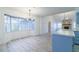 Open concept featuring a stone fireplace, light blue kitchen cabinets, and wood-look floors at 828 Ne 51St Ave, Ocala, FL 34470