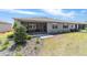 The rear of the home features a screened lanai and a manicured lawn with lush landscaping at 8820 Sw 104Th Cir, Ocala, FL 34481