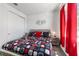 Cozy bedroom with white closet doors, a patterned bedspread, and bright red curtains at 8820 Sw 104Th Cir, Ocala, FL 34481