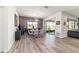 This dining room features a modern chandelier, a large window, and wood flooring at 8820 Sw 104Th Cir, Ocala, FL 34481