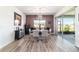 Bright dining room features modern light fixture, neutral walls, wood-look floors, and outdoor views at 8820 Sw 104Th Cir, Ocala, FL 34481